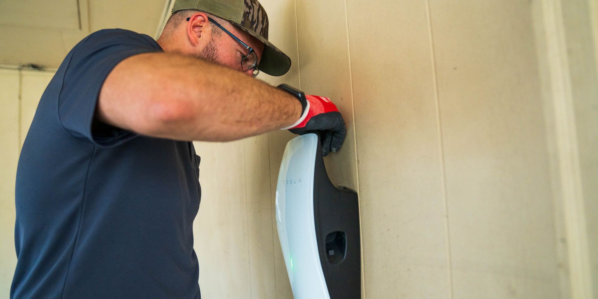 Electrician installing a wall-mounted Level 2 home EV charger